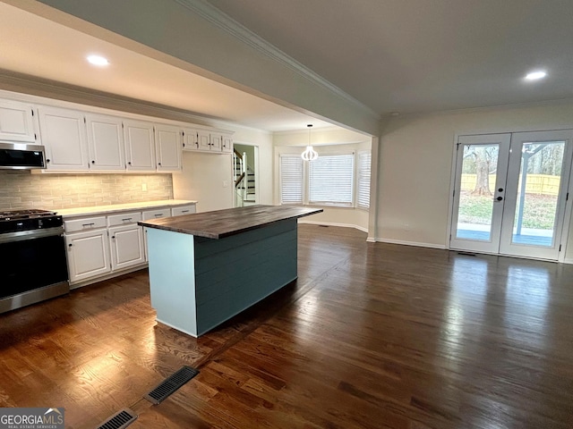 kitchen featuring dark wood-style flooring, stainless steel microwave, plenty of natural light, and range with gas stovetop