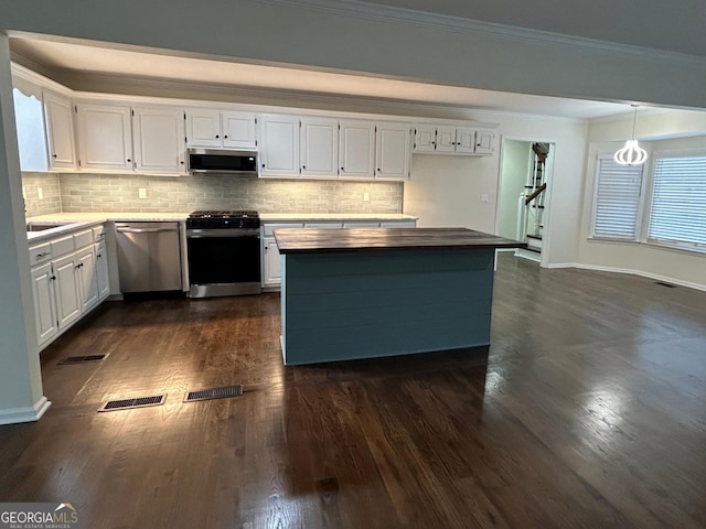 kitchen featuring crown molding, stainless steel appliances, visible vents, dark wood-type flooring, and white cabinetry