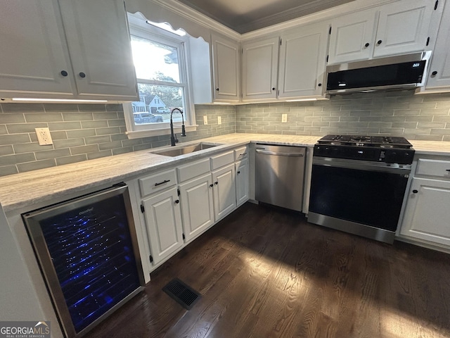 kitchen with stainless steel appliances, wine cooler, white cabinets, and a sink