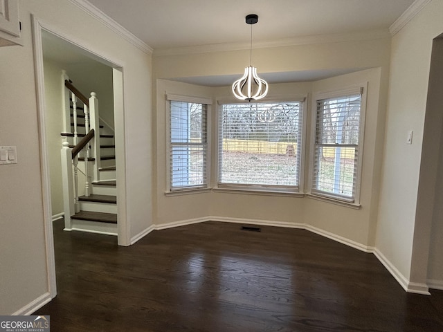 unfurnished dining area with crown molding, dark wood finished floors, baseboards, and stairs