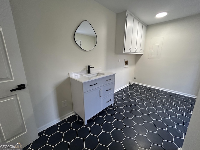 laundry area featuring washer hookup, cabinet space, a sink, and baseboards