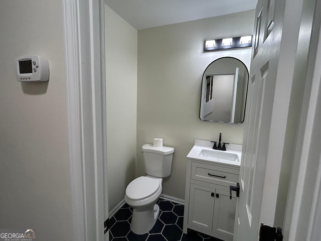 bathroom featuring tile patterned floors, vanity, toilet, and baseboards