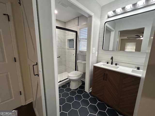 bathroom with visible vents, toilet, ceiling fan, vanity, and a shower stall