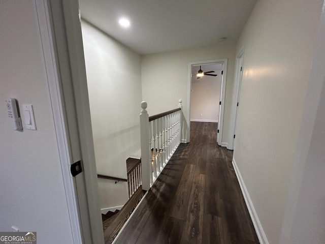 hallway featuring baseboards, an upstairs landing, and wood finished floors