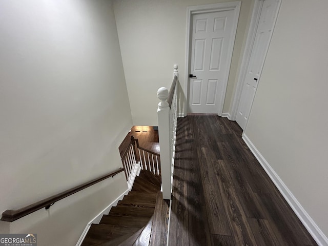 staircase with baseboards and wood finished floors