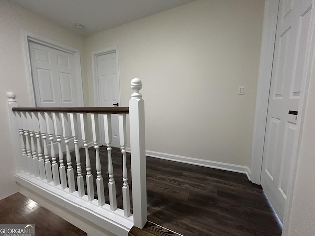 staircase featuring baseboards and wood finished floors