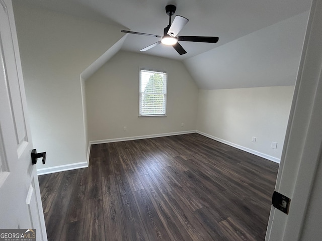 bonus room with vaulted ceiling, ceiling fan, dark wood-style flooring, and baseboards