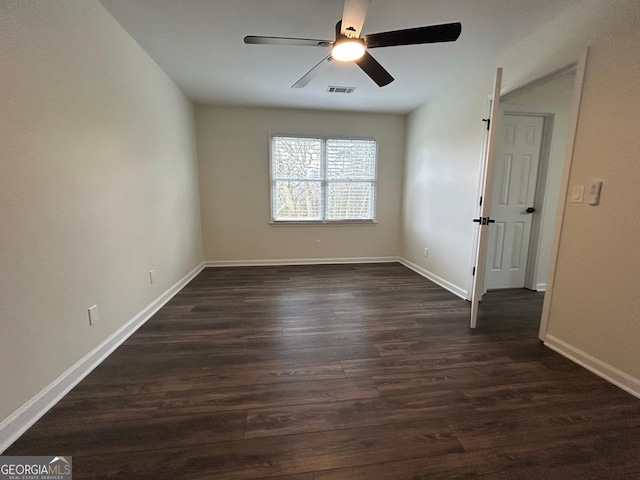 unfurnished bedroom with dark wood-style flooring, visible vents, and baseboards