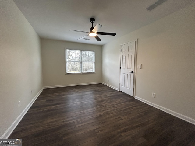 unfurnished room featuring dark wood-style floors, baseboards, visible vents, and a ceiling fan