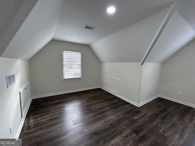 bonus room featuring baseboards, vaulted ceiling, visible vents, and dark wood finished floors