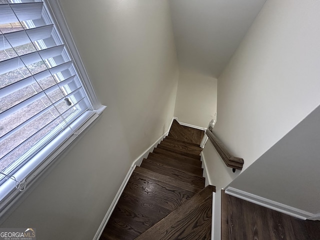 staircase featuring wood finished floors and baseboards