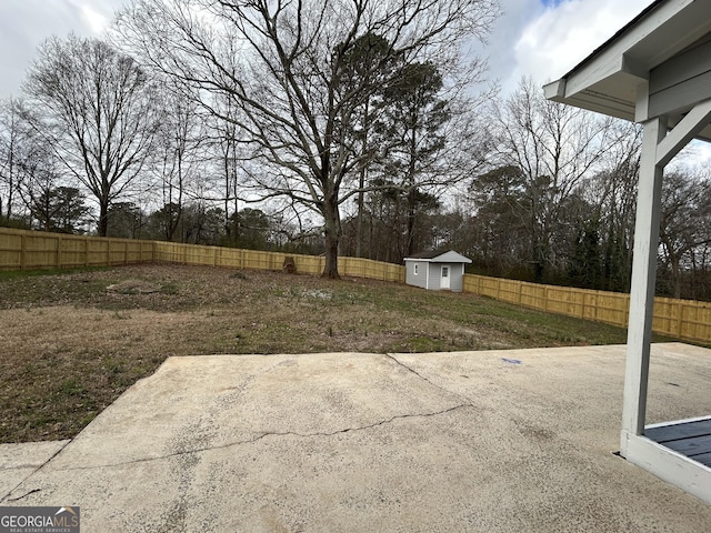 view of yard with a fenced backyard, a storage unit, an outbuilding, and a patio