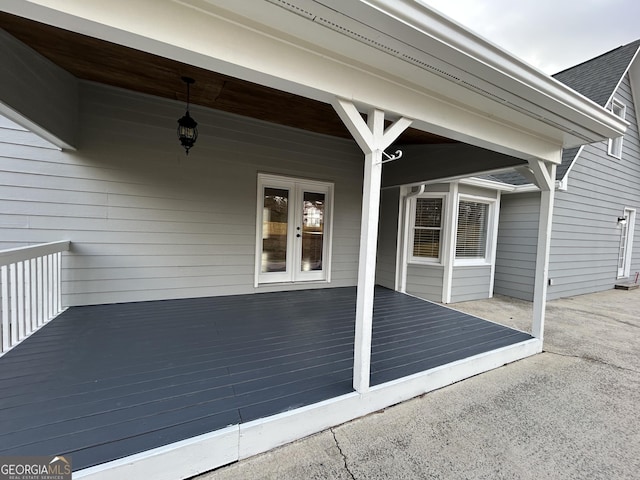 exterior space featuring a shingled roof and french doors