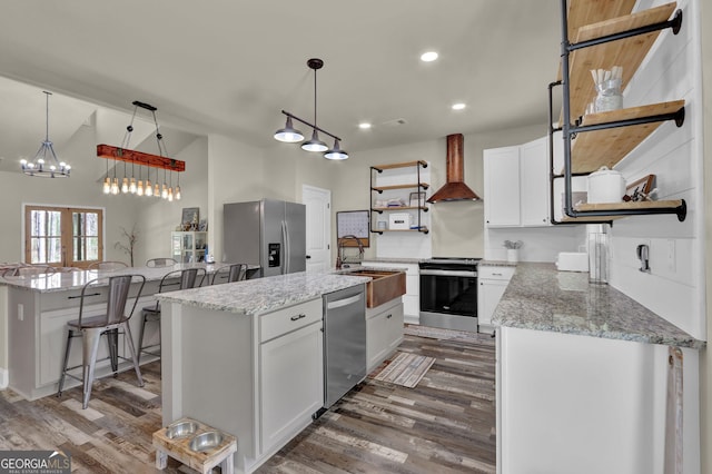 90 Jefferson Rd, Statham, GA 30666 - kitchen featuring an island with sink, open shelves, a sink, wall chimney exhaust hood, and appliances with stainless steel finishes