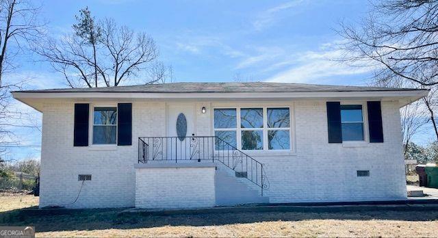 view of front facade featuring brick siding and crawl space