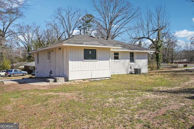 exterior space with brick siding, a lawn, and central air condition unit