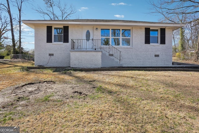 single story home featuring crawl space, a front lawn, and brick siding