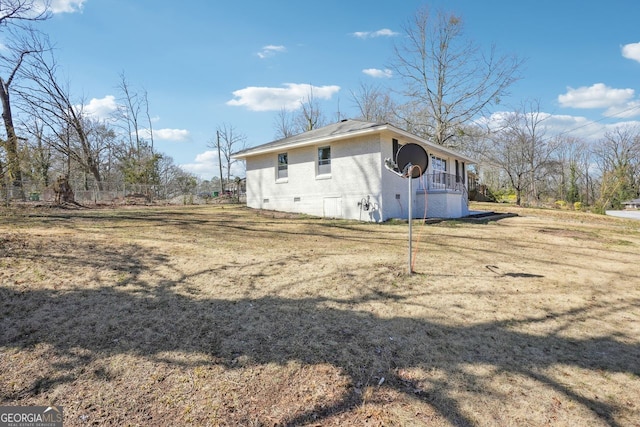 view of side of property featuring crawl space, a lawn, and brick siding