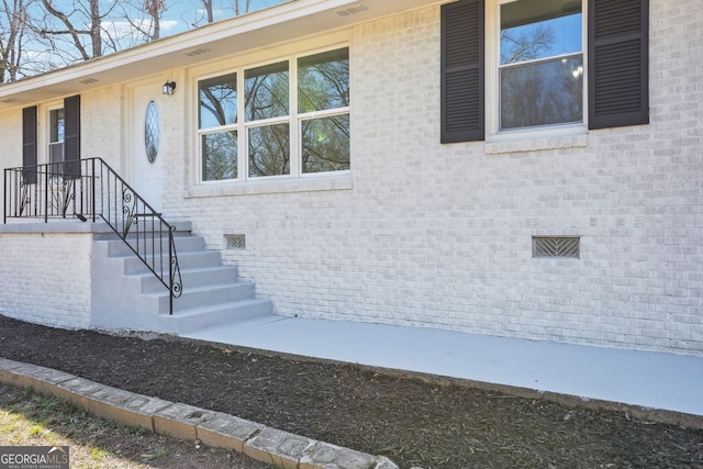 doorway to property with brick siding and crawl space