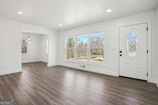 entrance foyer with a wealth of natural light, visible vents, baseboards, and dark wood-type flooring