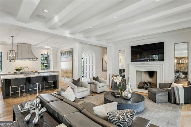 living room featuring beam ceiling, light wood-style flooring, recessed lighting, and a fireplace