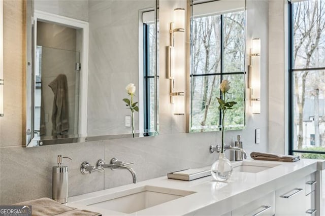 full bath with decorative backsplash, double vanity, and a sink