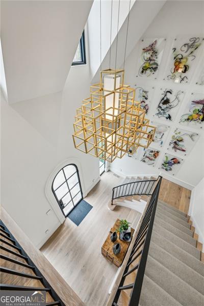 stairway featuring a towering ceiling and wood finished floors