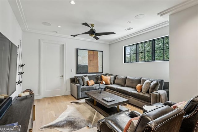 living room with visible vents, ceiling fan, light wood-style floors, and ornamental molding