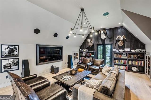 living room with wood finished floors, baseboards, lofted ceiling, french doors, and a chandelier