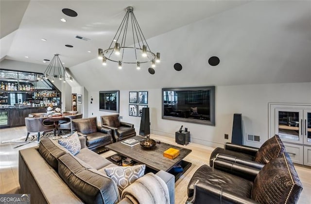 living room with visible vents, lofted ceiling, bar area, and wood finished floors