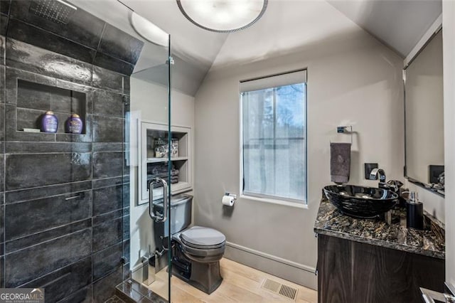 full bathroom with vanity, baseboards, visible vents, lofted ceiling, and toilet