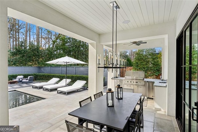 view of patio featuring outdoor dining area, exterior kitchen, ceiling fan, and fence