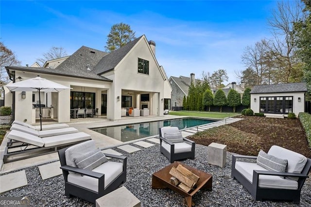 outdoor pool with an outdoor structure, outdoor lounge area, and a patio