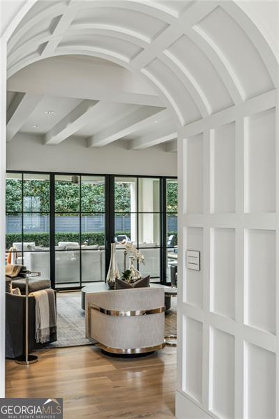 interior space with beam ceiling and wood finished floors