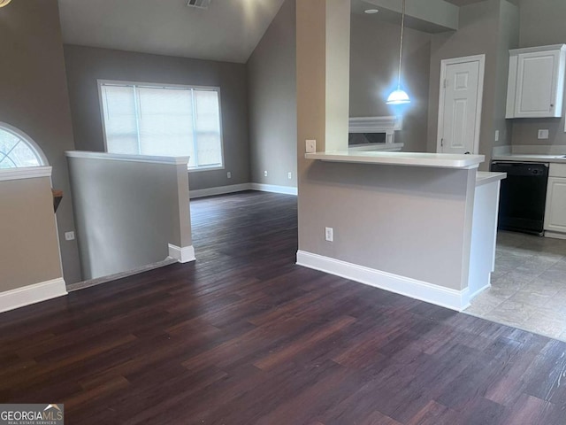 kitchen with black dishwasher, baseboards, wood finished floors, light countertops, and white cabinetry