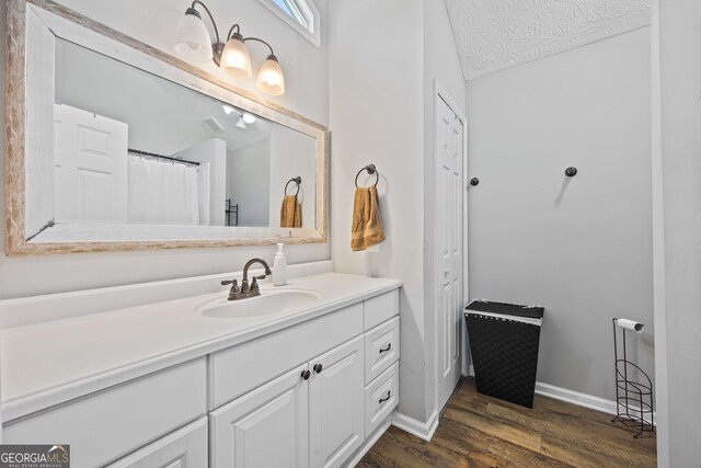 bedroom with wood finished floors, baseboards, and an office area