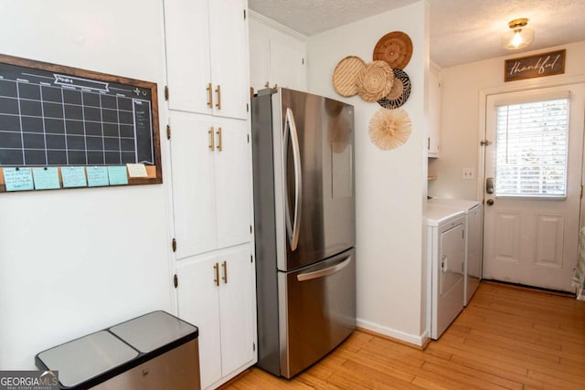 kitchen featuring freestanding refrigerator, white cabinetry, a textured ceiling, and light wood finished floors