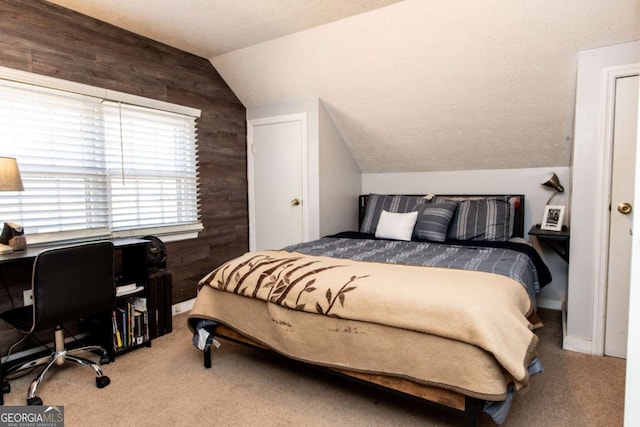 carpeted bedroom featuring lofted ceiling, wooden walls, and a textured ceiling