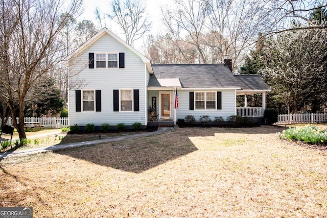 traditional-style home with a chimney and fence