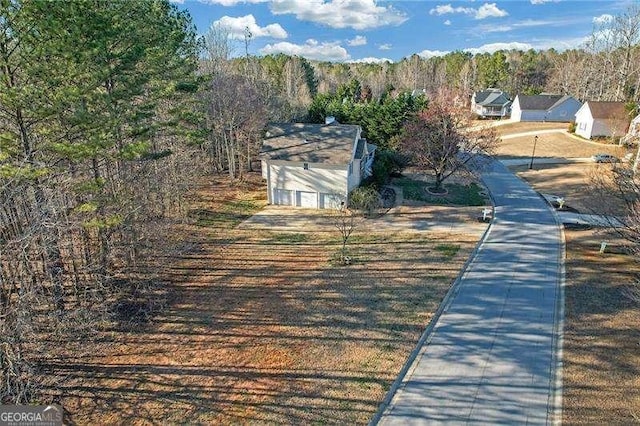 view of road with curbs and a wooded view