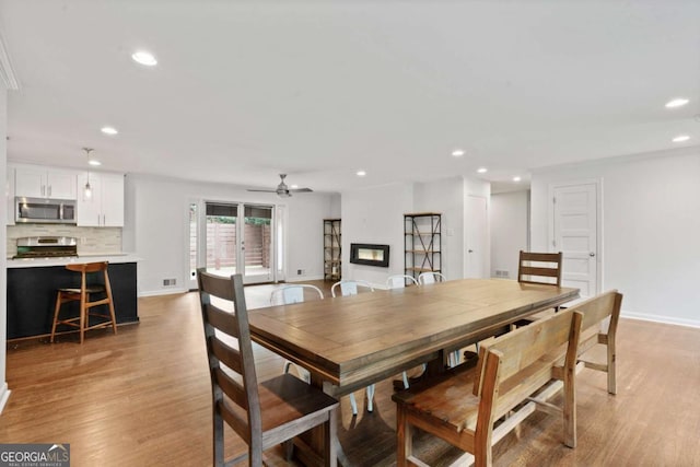 dining space featuring baseboards, light wood-style flooring, and recessed lighting