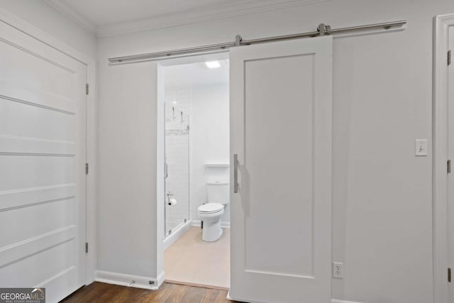 full bathroom featuring baseboards, toilet, ornamental molding, wood finished floors, and a shower stall