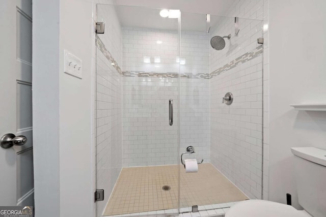 full bathroom with a stall shower and toilet