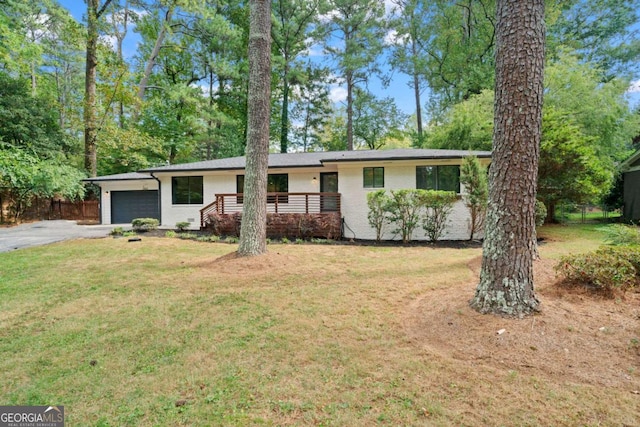 single story home with aphalt driveway, an attached garage, fence, a front lawn, and brick siding