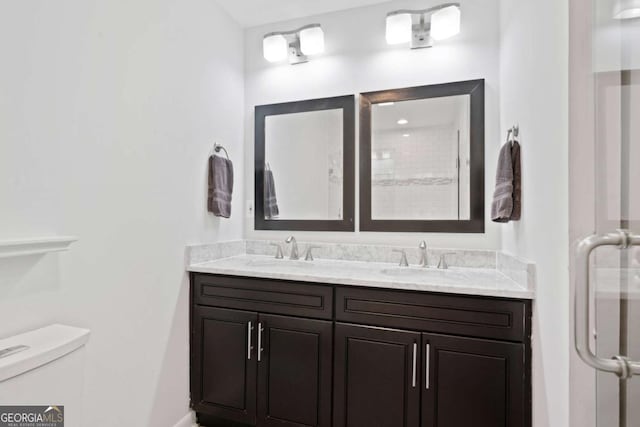 full bathroom featuring a sink, toilet, and double vanity