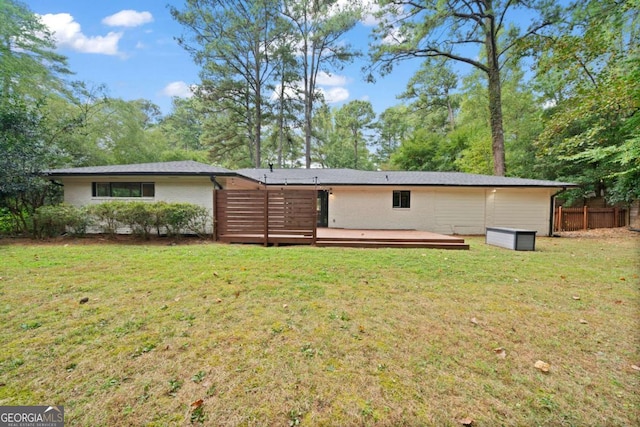 back of house with a yard, brick siding, fence, and a deck