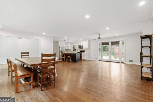 dining area with baseboards, wood finished floors, visible vents, and recessed lighting