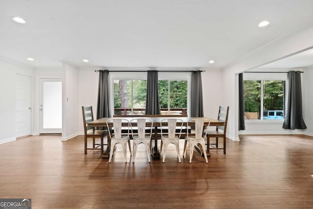 dining area featuring ornamental molding, baseboards, and wood finished floors