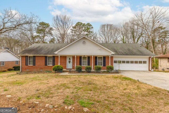 ranch-style home featuring a garage, a front yard, concrete driveway, and brick siding