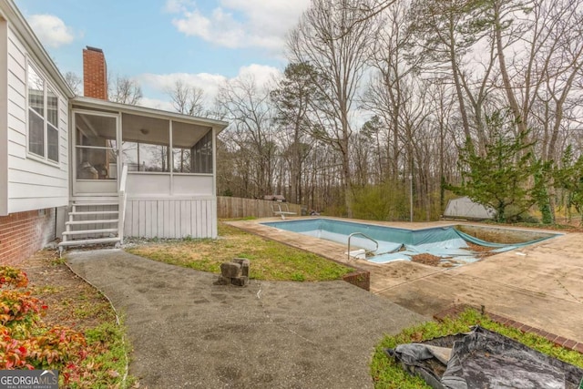 view of pool with a patio, fence, a sunroom, a diving board, and a covered pool